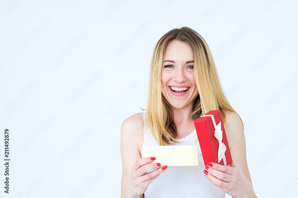 joyful smiling young woman with present in a red gift box. unexpected nice surprise. festive occasion greeting and holiday celebration concept joyful smiling young woman with present in a red gift box. unexpected nice surprise. festive occasion greeting and holiday celebration concept