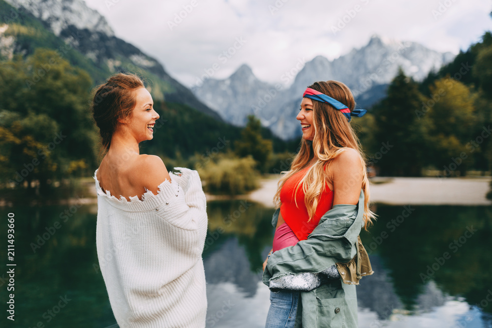 Two young tourist women have fun on the lake