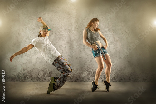 Fototapeta Naklejka Na Ścianę i Meble -  Hip Hop dancer in dynamic action jump on the grunge grey background