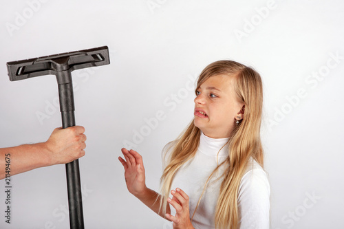 Фотография Hand holding a vacuum cleaner floor tool but the girl hates housework so she refuses it