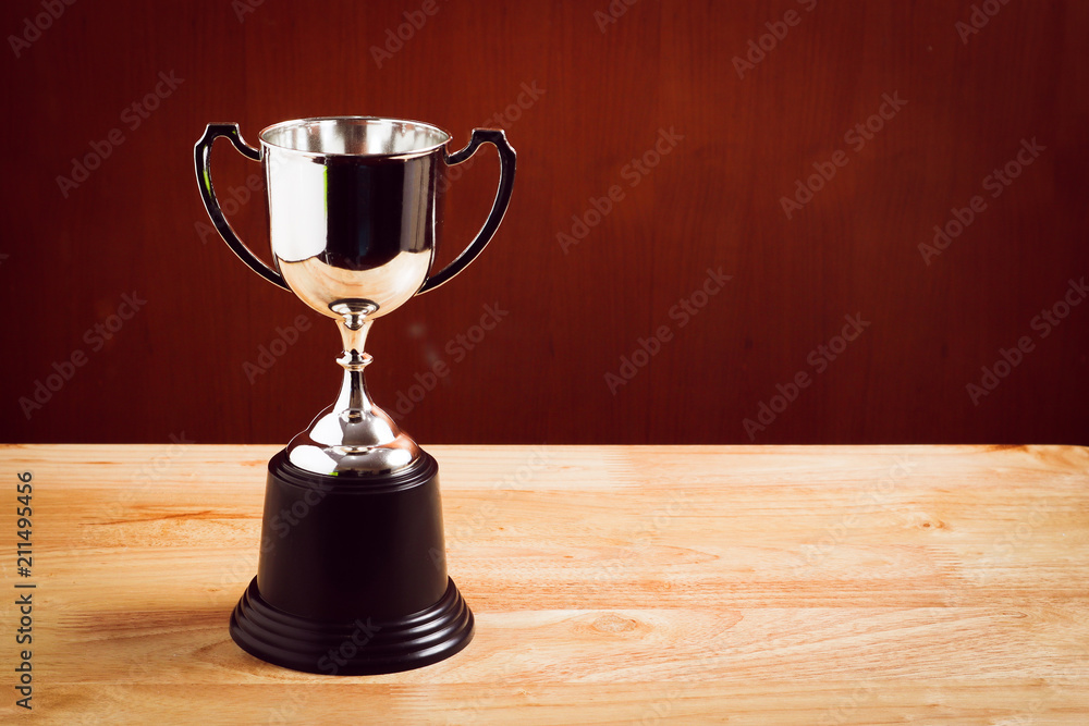winner concept silver trophy placed on wooden table with background. winner concept silver trophy placed on wooden table with background.