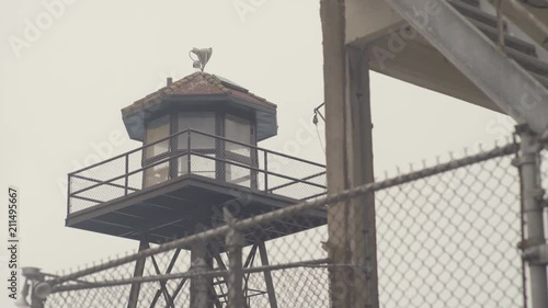 San Francisco Bay - Alcatraz island during foggy day - guard tower with fence, dynamic dolly shot