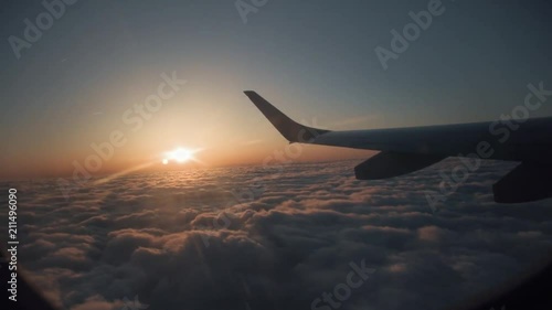 A view from the window seat of an airplane during sunset above the clouds. photo