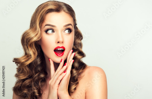 Obraz na plátně Shocked and surprised girl looking to the side presenting  your product