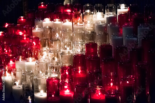 White and red candles lit up in a church, burning brightly