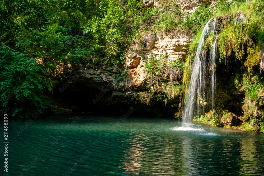 Waterfall and a beautiful lagoon lake for relaxing in the summer forest. Waterfall and a beautiful lagoon lake for relaxing in the summer forest.