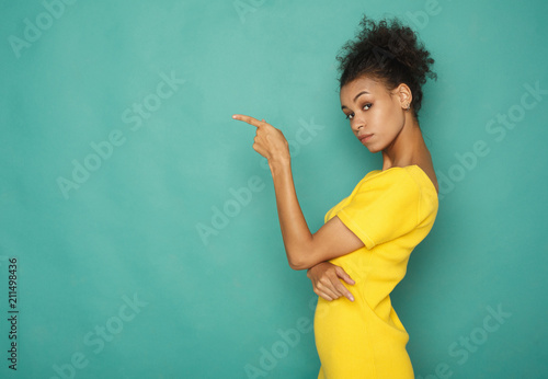 Young african-american woman point away