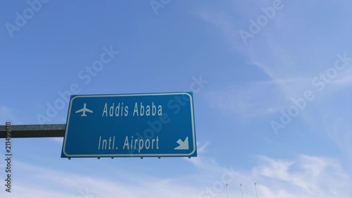 addis ababa airport sign airplane passing overhead photo