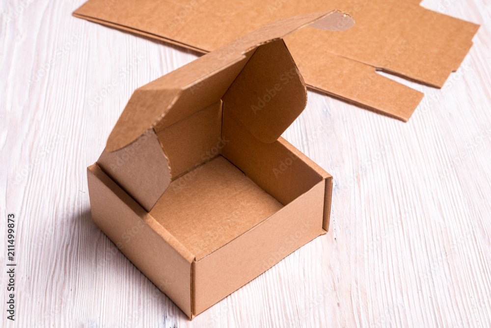 Small cardboard box on wooden desk Small cardboard box on wooden desk
