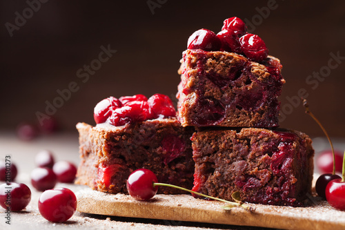 Billede på lærred Chocolate brownie pieces decorated with red cherry