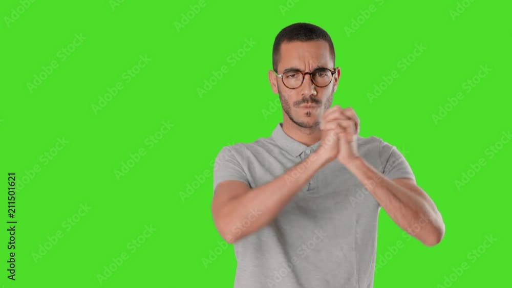 Serious young man doing a gesture of teamwork on chroma screen Serious young man doing a gesture of teamwork on chroma screen