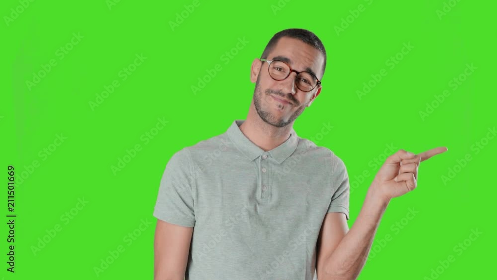 Confident young man on chroma screen and pointing with his hand Confident young man on chroma screen and pointing with his hand