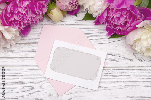 Peony flowers border blank greeting card white wooden background.