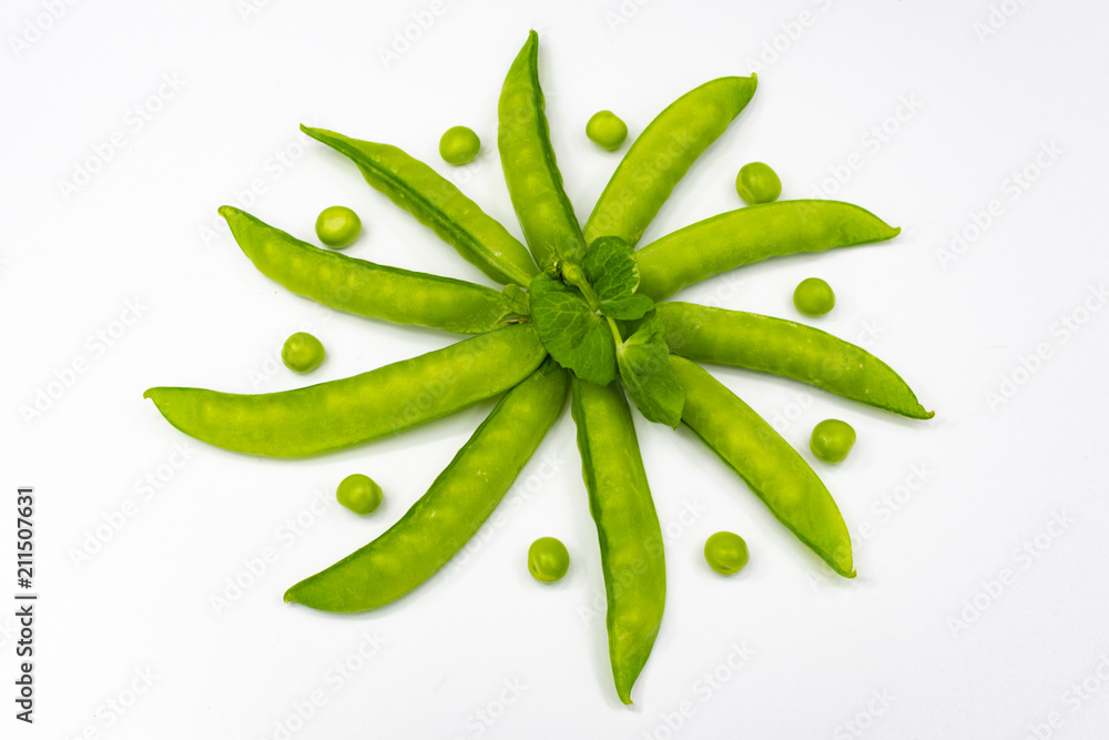 pods of young green peas lined in a circle in a shuffle with green peas on a white background pods of young green peas lined in a circle in a shuffle with green peas on a white background