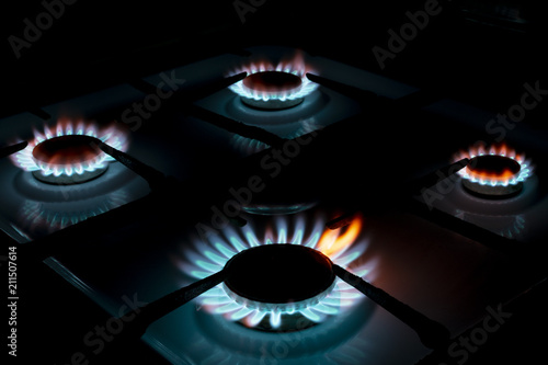 burning four gas cookers, in the dark, closeup