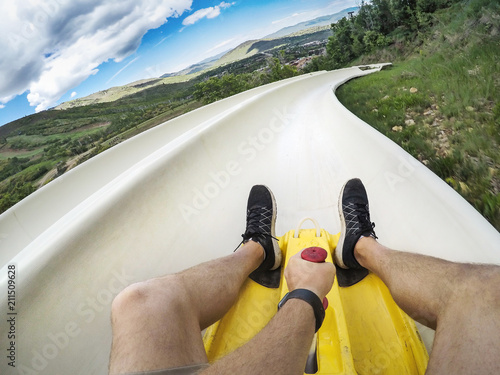 Fotografie Point of view photo of a man riding down an downhill alpine slide on a fun summe