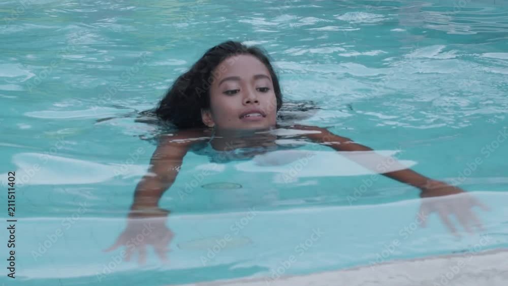 Beautiful sexy lady in bikini posing in the swimming pool. Portrait of fashion model girl outdoors. Beauty woman with attractive body in swimsuit Beautiful sexy lady in bikini posing in the swimming pool. Portrait of fashion model girl outdoors. Beauty woman with attractive body in swimsuit