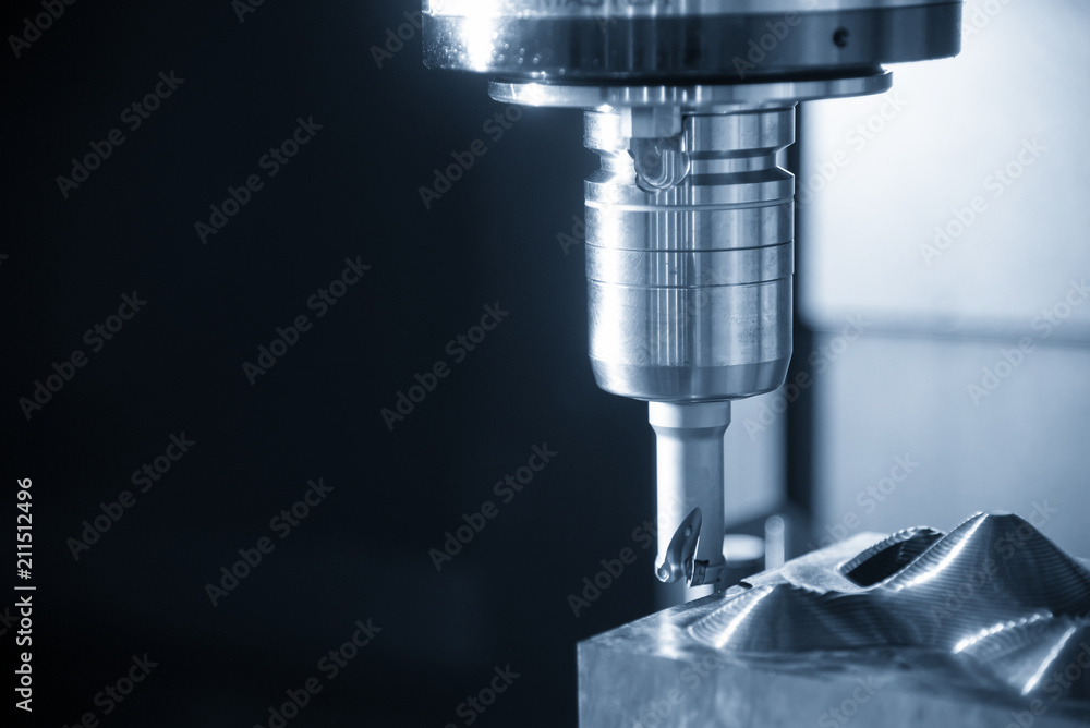 The CNC milling machine cutting the mold part in roughing process with the index-able ball endmill tool.Hi-technology manufacturing process. The CNC milling machine cutting the mold part in roughing process with the index-able ball endmill tool.Hi-technology manufacturing process.