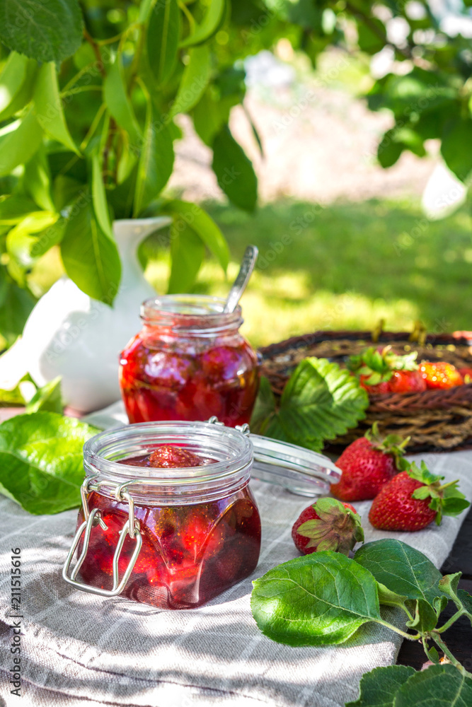 Strawberry jam and juicy ripe strawberries on a wooden table in the garden on a summer sunny afternoon in a rustic style, the concept of gardening, healthy organic vitamin nutrition Strawberry jam and juicy ripe strawberries on a wooden table in the garden on a summer sunny afternoon in a rustic style, the concept of gardening, healthy organic vitamin nutrition