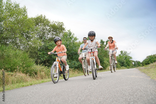 Kids with parents riding bikes in countryside