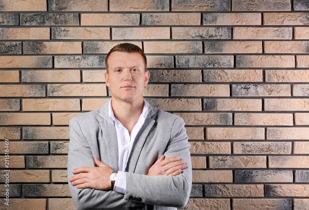 Handsome young man in suit near brick wall background Handsome young man in suit near brick wall background