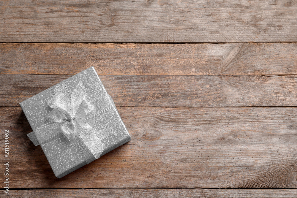 Fototapeta premium Beautiful gift box on wooden background, top view