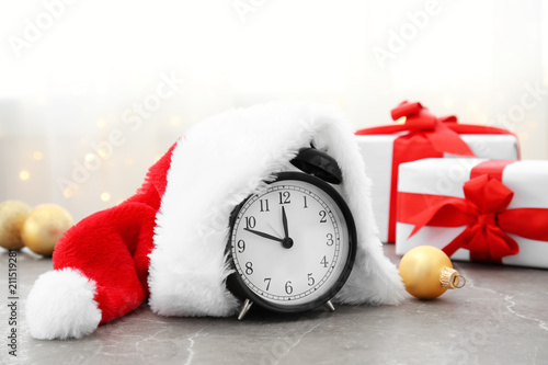 Alarm clock and Santa hat on table. Christmas countdown