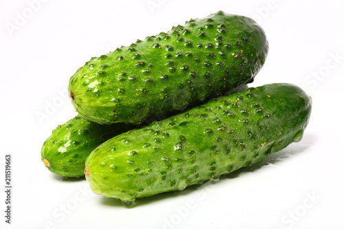 Three fresh organic cucumbers on white background photo