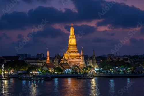 The boat was sailing in Chao Phraya River, background Wat Arun at sunset time ,Bangkok, Thailand. The Temple of Dawn