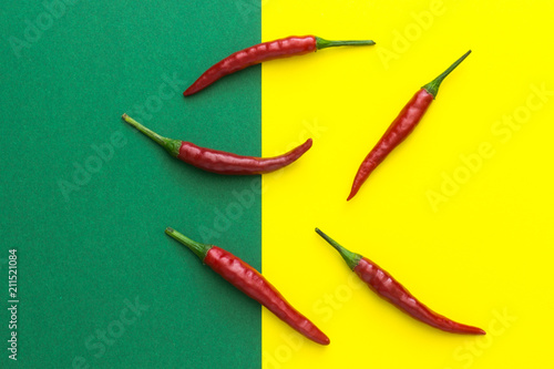 five red chili peppers on a yellow-green background