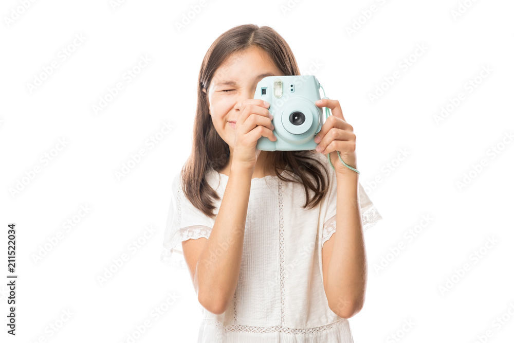 Fototapeta premium Portrait on a young girl clicking photos with camera isolated on white background