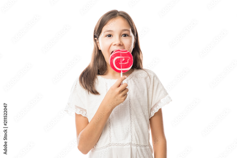 Beautiful cute little girl eating lollipop