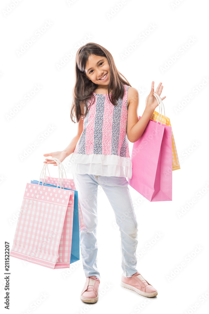 Sweet girl in jeans and top holding colorful paper shopping bags Sweet girl in jeans and top holding colorful paper shopping bags