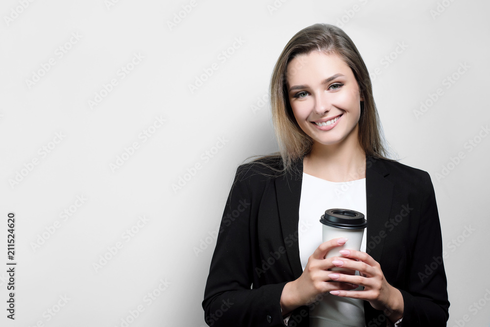 Beautiful businesswoman businesswoman Worker office resting, drinking and holding a paper glass with coffee. White background, Black suit and blouse. Beautiful businesswoman businesswoman Worker office resting, drinking and holding a paper glass with coffee. White background, Black suit and blouse.