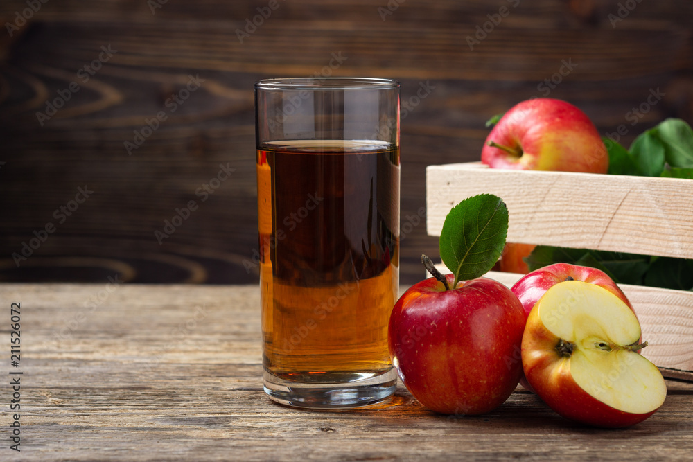 Glass of apple juice with red apples on wooden table Glass of apple juice with red apples on wooden table