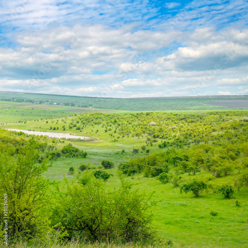 Green field and blue sky. Picturesque hills formed by an old river terrace. Moldova. Agricultural landscape.