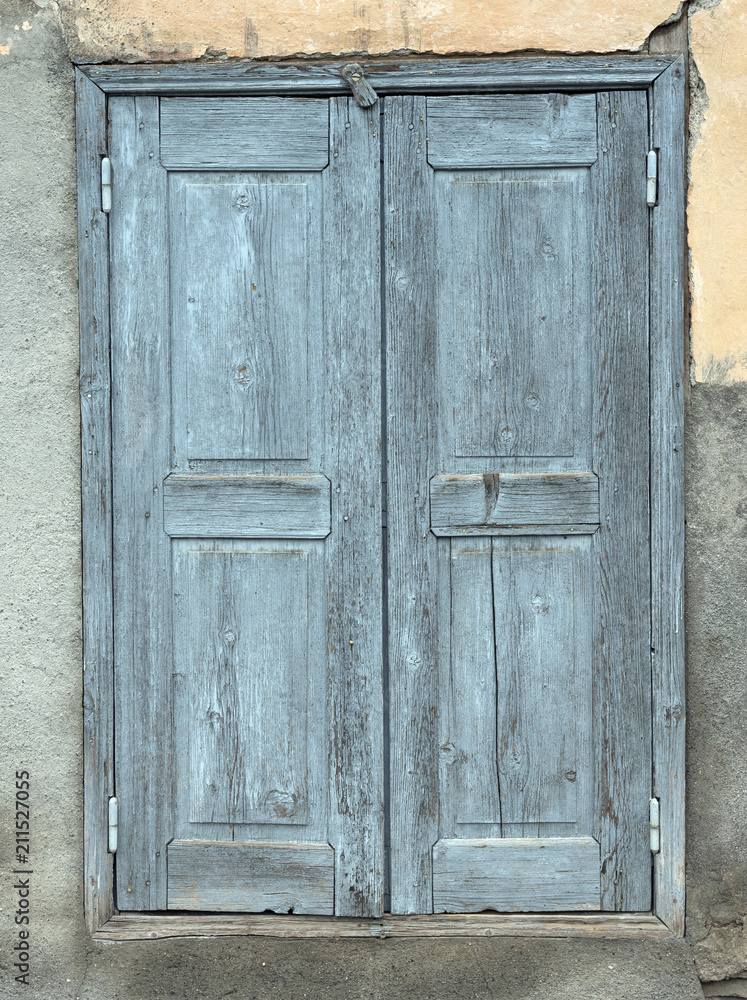 old blue painted closed shutters in wall of house in french provence