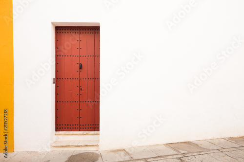 a white-yellow wall with a brown door in the Mediterranean style.