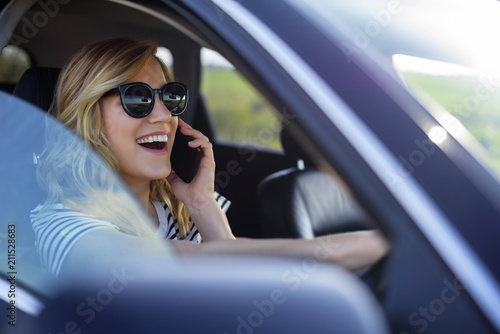 Woman speaks on the phone in the car.