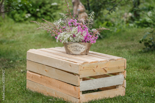 букет цветов на деревянном ящике в  летнем саду