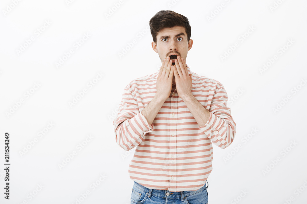 No way, cannot believe you. Portrait of shocked stunned charming male model in striped shirt, dropping jaw, holding palms near opened mouth, being devastated and wondered with shocking news No way, cannot believe you. Portrait of shocked stunned charming male model in striped shirt, dropping jaw, holding palms near opened mouth, being devastated and wondered with shocking news