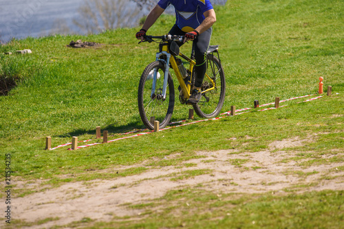 Closeup of male cyclist riding on green grass track