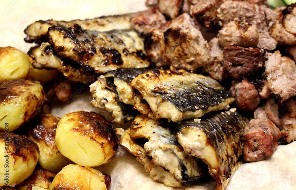 fried fish on the grill potatoes and meat