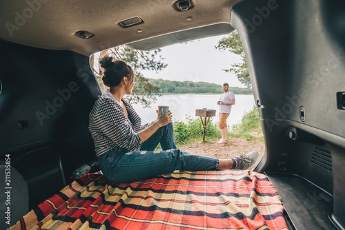 couple resting outside. car travel concept. sitting in trunk