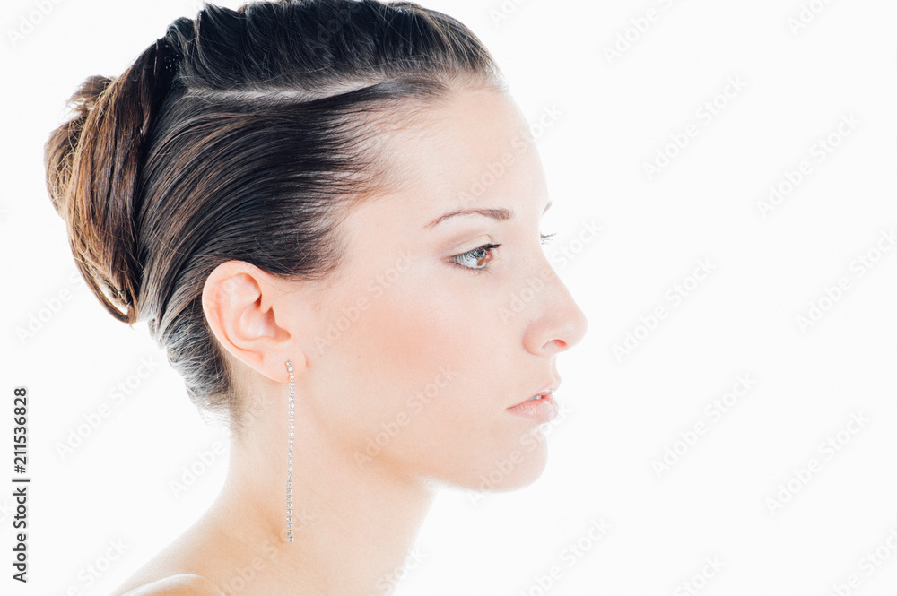 Profile of a young caucasian brunette poses for a beauty session in studio with white background Profile of a young caucasian brunette poses for a beauty session in studio with white background