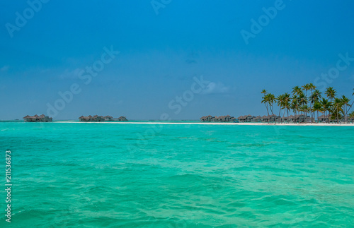 Tropical beach with palms on the background of the island. Perfect escape. Honeymoon  © Maria