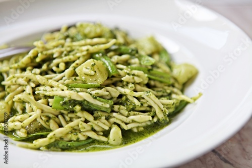 Traditional handmade Ligurian Pasta Trofie with fresh Pesto alla Genovese sauce . Natural light. photo