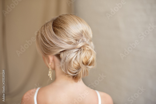 Rear view of female hairstyle middle bun with blond hair. photo