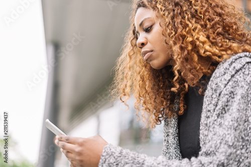 Fotografie Pretty young black woman with mobile