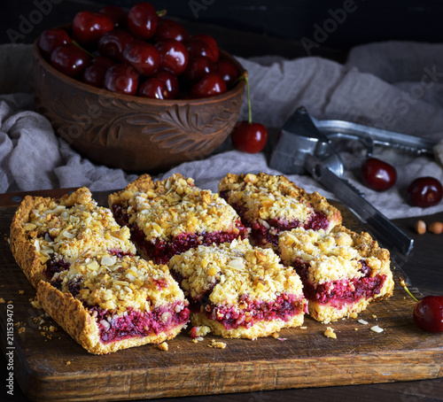 square pieces of cake crumble with cherry photo